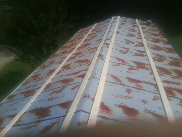 Rusted metal roof panels with new wood purlins before replacement — Storm Damage Roof Repair in Pleasant Ridge by Roofing Brothers
